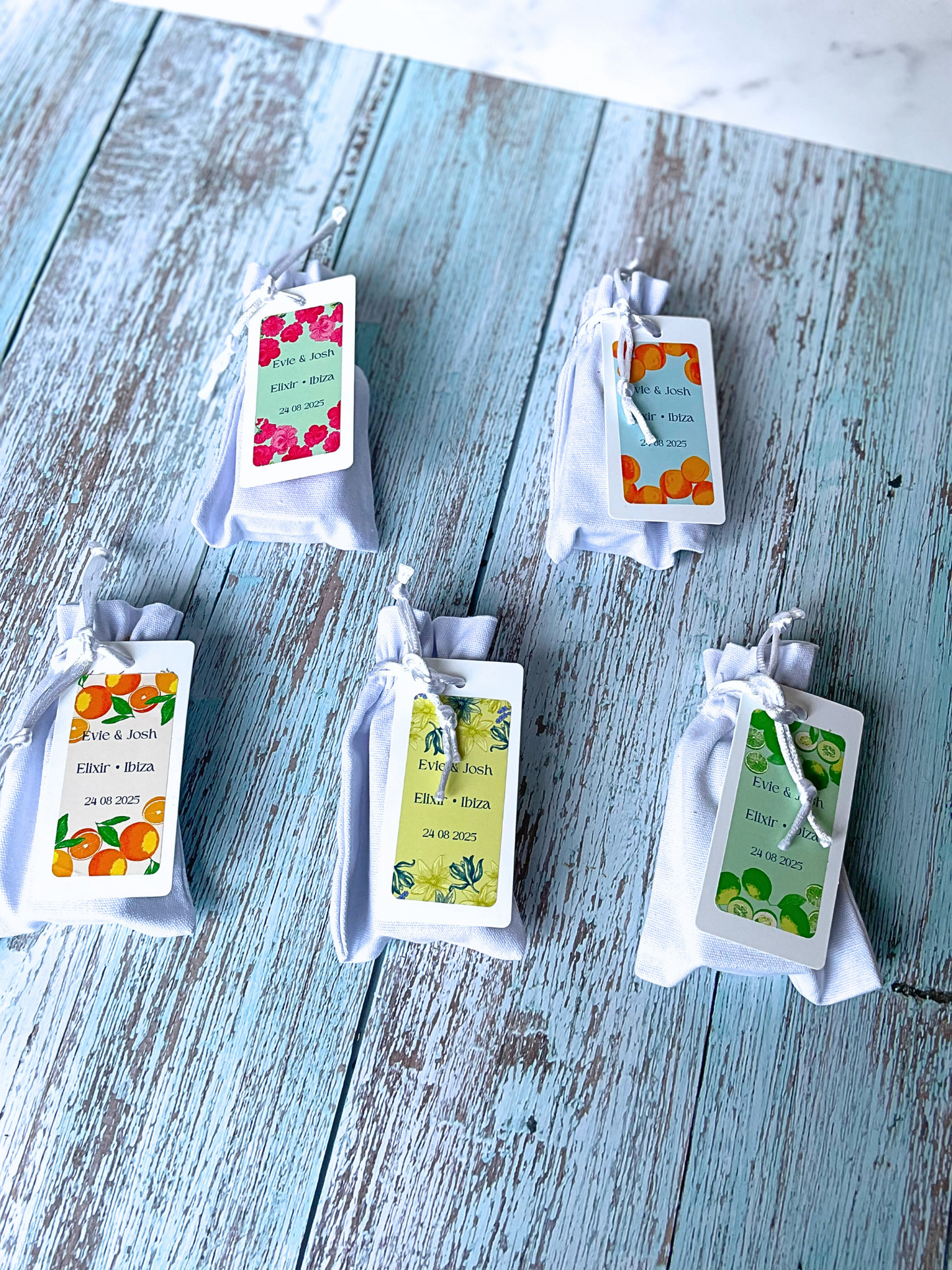 Five different soap favours with colourful botanical branding encased in luxury white cotton bags with silk drawstrings.  Rose Geranium soap wedding event favour, Eucalyptus Rosemary and Apricot soap wedding event favour, Cedar and Orange wedding event favour, Ylang Ylang Lavender and Lemongrass soap wedding event favour, Cucumber Spearmint and lime wedding event favour all can be used for weddings, baby showers, corporate events and corporate gifting